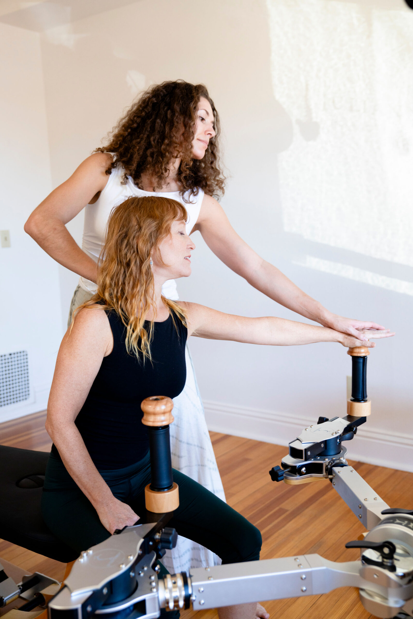 Client performing guided arm movement on Gyrotonic equipment.