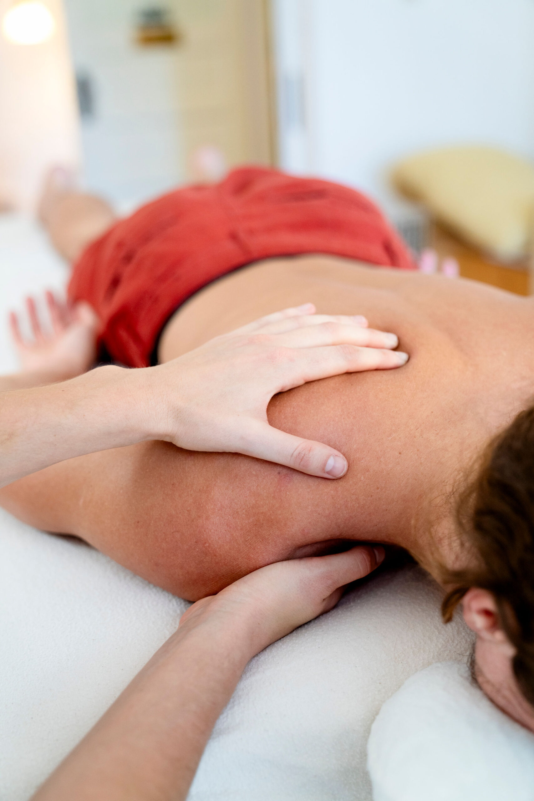 Rolfer working with a client’s shoulder on the treatment table.